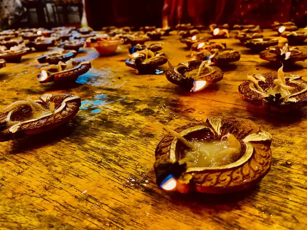 Rows of lit clay diyas during the evening puja